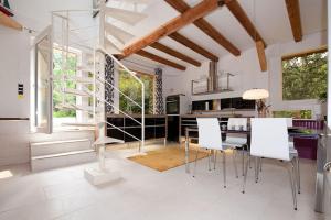 a kitchen with a dining table and white chairs at Chalet Stahl - Ferienhaus mit Pool in Freiburg im Breisgau