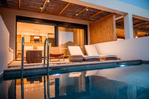 a villa with a swimming pool and a house at Acacia - Explore your senses in Preveza