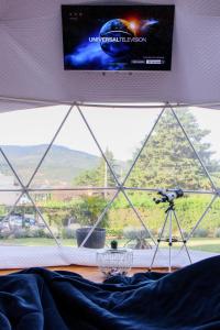 a television on a wall above a bed with a camera at Samaipata Glamping in Samaipata