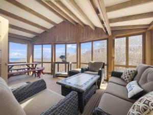 Una sala de estar con sofás, una mesa y ventanas. en Seacoast Sanctuary Brought to you by GetAway Vacations, en Cape Neddick
