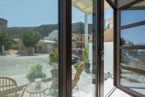 a view from a window of a patio with a table and chairs at Kyma beach - Apollon apartment - 2ad & 2kids in Kolymvari