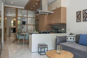 a living room and kitchen with a couch and a table at Kyma beach - Apollon apartment - 2ad & 2kids in Kolymvari