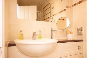 a bathroom with a white sink and a mirror at Tyn-y-Coed Inn in Betws-y-coed