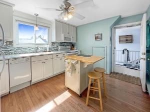 a kitchen with white cabinets and a table and stool at Sweet Serenity - Y846 condo in York