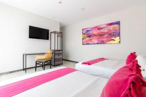 pokój hotelowy z dwoma łóżkami i telewizorem w obiekcie Arkana Grupo Amber - Collection O w mieście Puebla