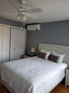a bedroom with a white bed with a ceiling fan at Beach House Brought to you by GetAway Vacations in York