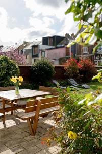 einem Picknicktisch aus Holz und einer Bank im Garten in der Unterkunft Villa Zachee - maison familiale & parking gratuit in Le Tréport