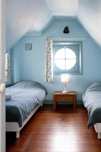2 Betten in einem blauen Schlafzimmer mit Fenster in der Unterkunft Villa Zachee - maison familiale & parking gratuit in Le Tréport