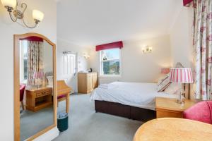 Schlafzimmer mit einem Bett und einem Spiegel in der Unterkunft Charles House - Windsor Castle in Windsor