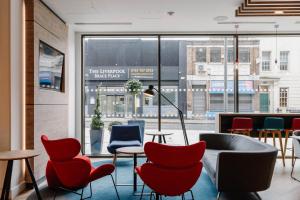 eine Lobby mit Stühlen und Tischen und einem großen Fenster in der Unterkunft Holiday Inn Express Liverpool - Central, an IHG Hotel in Liverpool