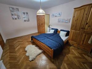 a bedroom with a bed with a blue comforter and a rug at Prostorný byt 3+1 pro 4 osob Možnost přistýlky+2os in Šumperk