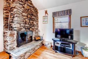 sala de estar con chimenea de piedra y TV de pantalla plana en Sweet Life home en Pittsfield