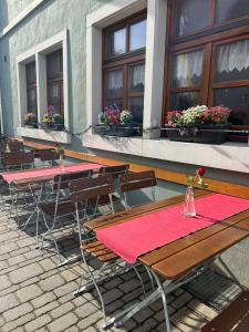 una fila de mesas y sillas con mantel rojo en Streng's Weinstube, en Sommerach