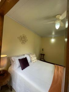 a bedroom with a bed with white sheets and pillows at Chalés Paraty Real in Paraty