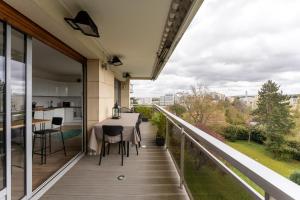 a balcony with a table and chairs and a view at Appartement de luxe, St Germain en Laye, Neuf in Saint-Germain-en-Laye