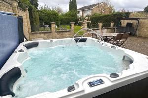 a hot tub with a water fountain in a backyard at Green Haven Villa - 4BR Spacious House with Hot tub, Ample Parking, Air Condition, WIFI, Netflix, Patio & Garden in Kidlington