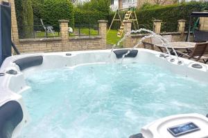a hot tub with a water fountain in a yard at Green Haven Villa - 4BR Spacious House with Hot tub, Ample Parking, Air Condition, WIFI, Netflix, Patio & Garden in Kidlington