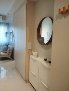 ein Bad mit einem Waschbecken und einem Wandspiegel in der Unterkunft S Residences in Manila