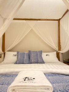 a bed with blue and white pillows in a tent at JOSEPHA COTTAGE in Ngurblut