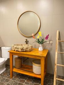 La salle de bains est pourvue d'un lavabo et d'un miroir sur une table. dans l'établissement JOSEPHA COTTAGE, à Ngurblut