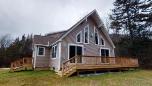 a house with a large deck on the side of it at The Mendon House home in Killington
