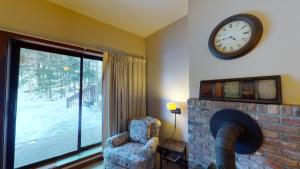 een woonkamer met een open haard en een klok aan de muur bij Wintergreen 106 condo in Pittsfield