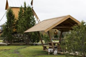 a wooden pavilion with a picnic table in a yard at Meela Talu Tuulik saunaga in Kuusiku