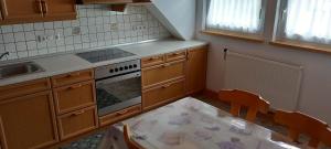 a kitchen with a table and a stove top oven at CasaRoberto Apartment 1 in Gosau