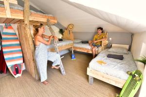 a man and a woman in a room with two beds at SURF HOSTEL BIARRITZ in Biarritz
