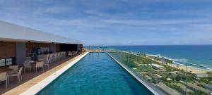 a hotel swimming pool with a view of the ocean at COSTE0104 - Premium Stella Maris in Salvador