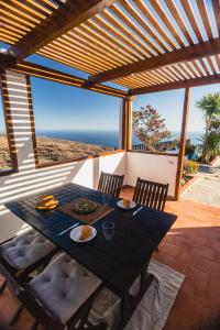 una mesa de comedor en un patio con vistas al océano en Casa Muna en El Cercado