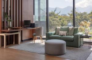 a living room with a green chair and a table at Fairfield by Marriott Bogota Embajada in Bogotá