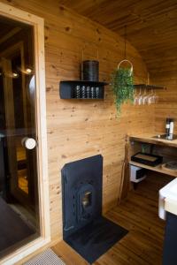 una estufa de leña en la cocina de una casa pequeña en Meela Talu Tuulik saunaga, en Kuusiku