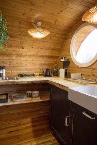 una cocina con paredes de madera y una ventana redonda en Meela Talu Tuulik saunaga, en Kuusiku