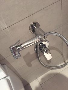 a hose hooked up to a toilet in a bathroom at Heda House in Sanyang