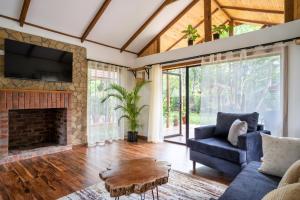 a living room with a fireplace and a blue couch at The Jungle Oasis with heated pool in Nairobi
