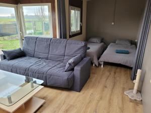un soggiorno con un divano e un letto di Maison au bord du canal a Pagny-la-Ville