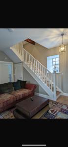 a living room with a couch and a stair case at Rokeby cottage in Drogheda