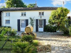 a white house with a bunch of barrels in front of it at Villa charmante à Arsac avec piscine privée et jardin in Arsac