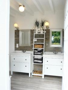 a bathroom with two sinks and two mirrors at Villa charmante à Arsac avec piscine privée et jardin in Arsac