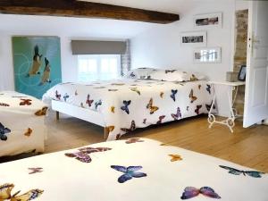 ein Schlafzimmer mit zwei Betten mit Schmetterlingen drauf in der Unterkunft Villa de 3 chambres avec piscine privee jardin clos et wifi a Arsac in Arsac