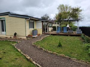 una casa con veranda e sedie su un patio di Maison au bord du canal a Pagny-la-Ville