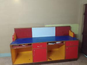 a toy desk with a blue top and red cabinets at lotus Abode in Salem