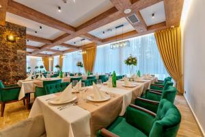 a restaurant with long tables and green chairs at BuzzStays - Spa & Wellness Hotel - Privately Managed Apartments in Zlatibor