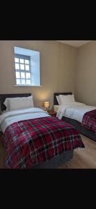 a bedroom with two beds and a window at Rokeby cottage in Drogheda