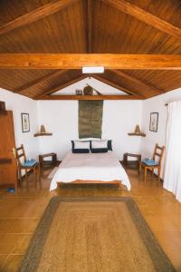 1 dormitorio con cama y techo de madera en Casa Muna en El Cercado