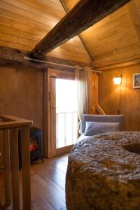 a bedroom with a bed and a fireplace and a window at Stiilne Tuulikumajutus saunaga in Kuusiku
