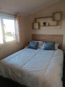 a large bed in a bedroom with a window at 4-Bedroom Caravan static home in Clacton-on-Sea in Clacton-on-Sea
