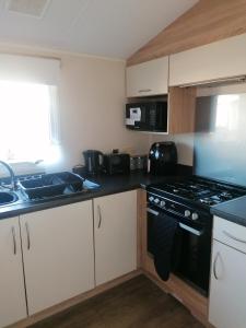 a kitchen with a stove and a sink at 4-Bedroom Caravan static home in Clacton-on-Sea in Clacton-on-Sea