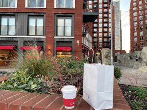 a coffee cup and a tote bag sitting on a brick sidewalk at Executive Luxury apartment in Vauxhall with balcony in London